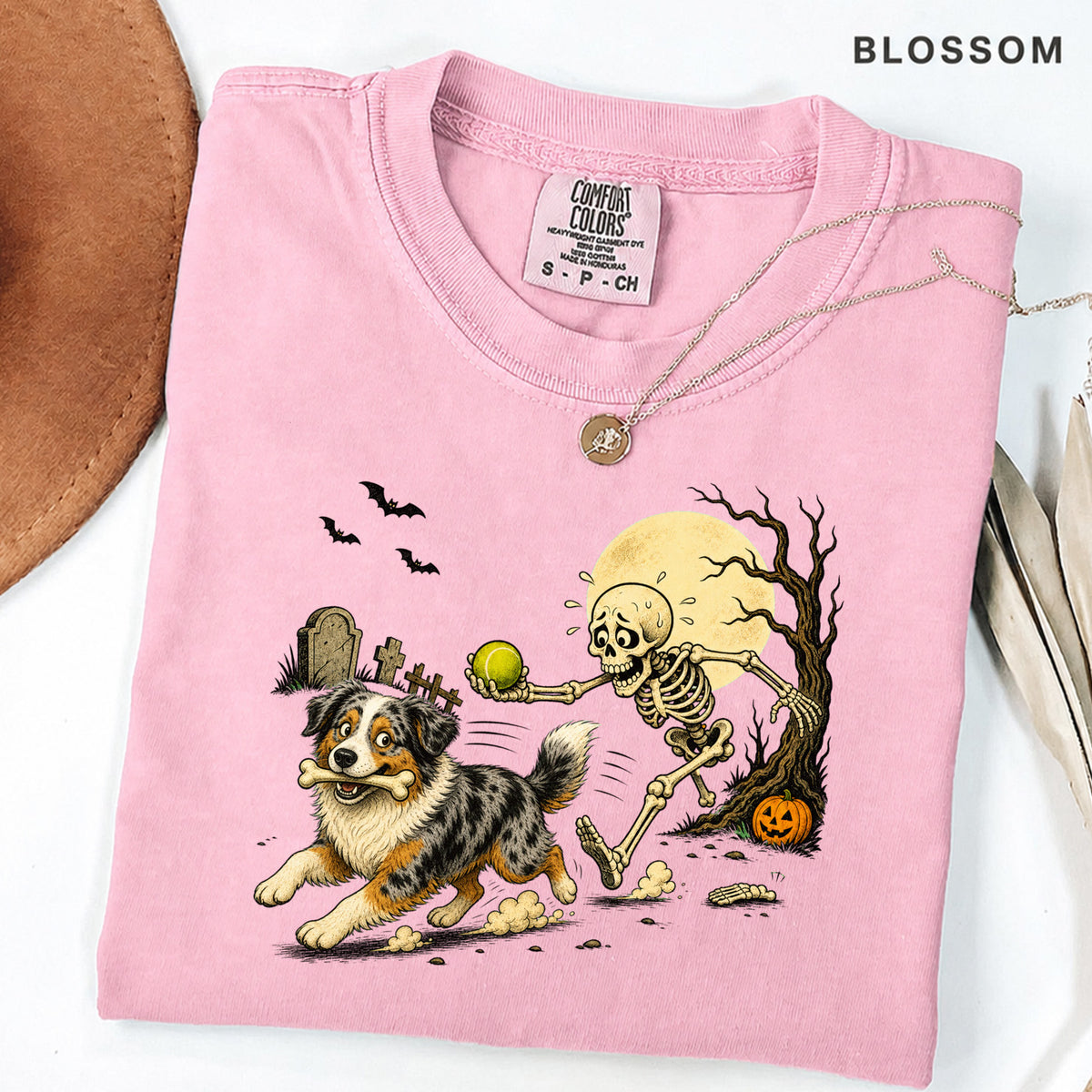 Skeleton Chasing Aussie Halloween Shirt T-Shirt in Blossom, vintage Halloween graphic tee with an Australian Shepherd and skeleton