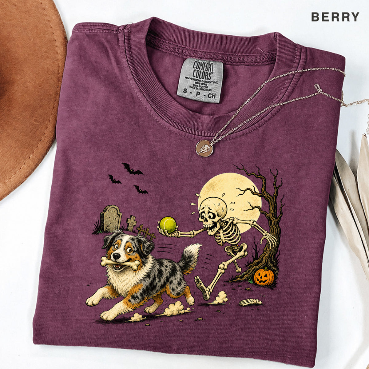 Skeleton Chasing Aussie Halloween Shirt T-Shirt in Berry, vintage Halloween graphic tee with an Australian Shepherd and skeleton